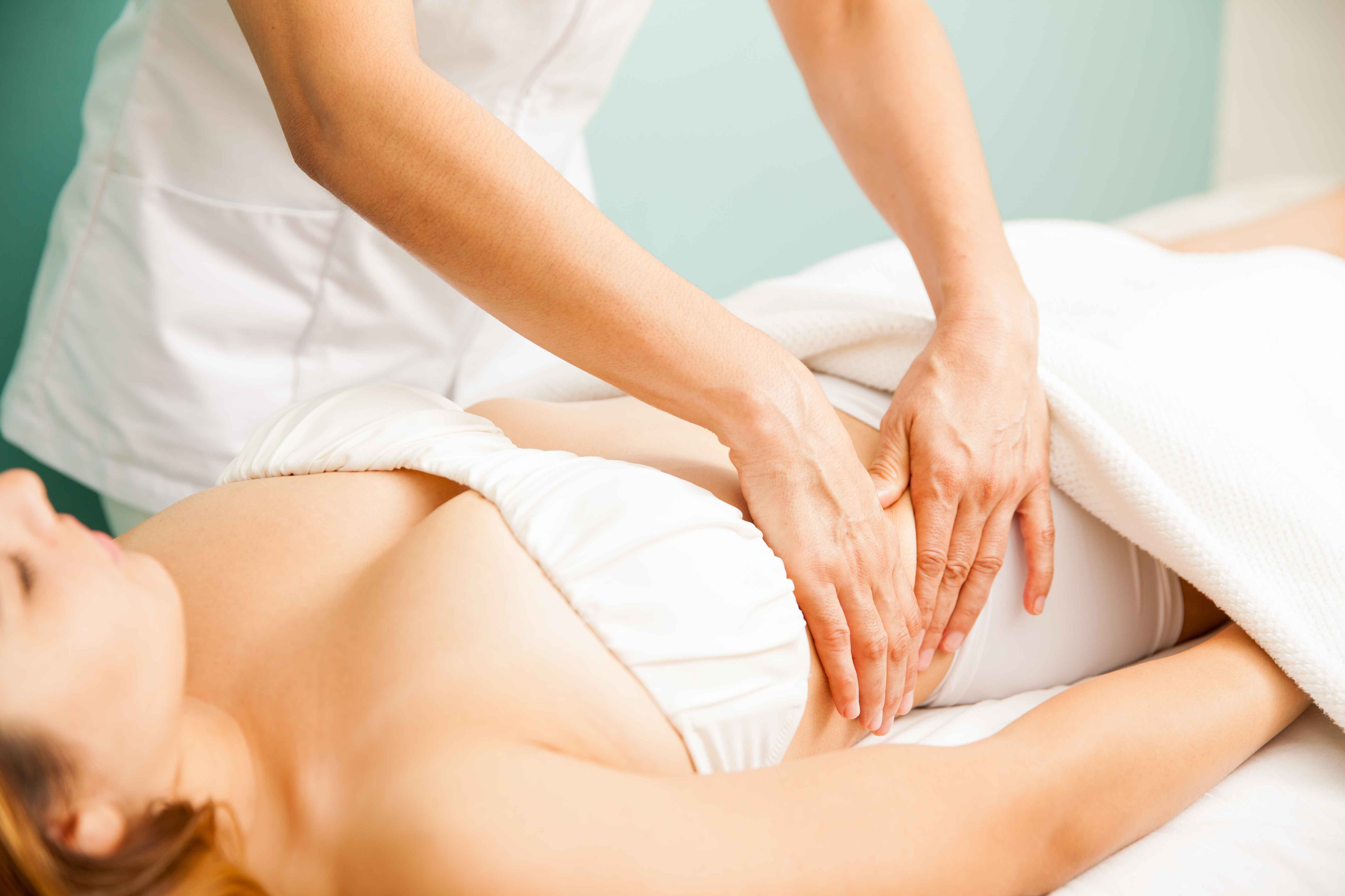 closeup hands therapist giving deep tissue massage female client spa